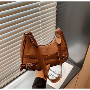 Gros plan d'un sac hobo marron doté de boucles décoratives et de texture en daim