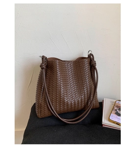 Close-up of coffee brown woven bucket bag featuring intricate texture and knot detail