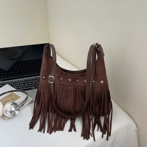 Vintage braune Handtasche aus Wildlederimitat mit Sternnieten und langen Fransen auf Tisch