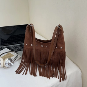 Braune Wildleder-Tasche mit Fransen und Sternennieten in gemütlicher Büroumgebung