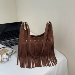 Vintage braune Wildleder-Hobotasche mit langen Fransen und Sternennieten auf dem Tisch