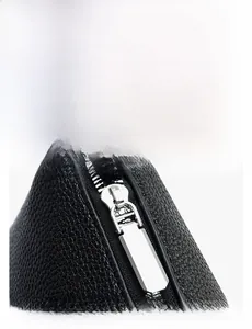 Detail of smooth metal hardware zipper on black lychee grain leather tote bag