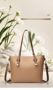 Macro detail of brown pebble grain leather tote bag showing kangaroo logo and texture