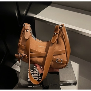 Détail du sac hobo marron montrant la texture daim, les bords cuir et les boucles en métal