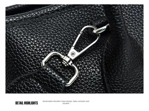 Detail view of black lychee leather bag with detachable silver metal swivel hooks