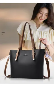 Detail of black pebbled leather tote bag with brown straps and kangaroo logo
