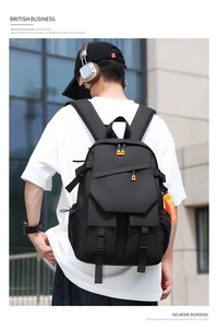 Detail of durable black laptop backpack with vibrant orange zippers and side straps