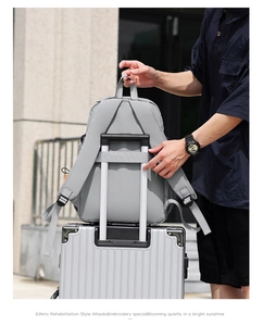 Detail of light grey travel backpack with luggage strap for suitcase handle attachment