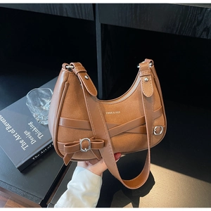Détail du sac bandoulière marron demi-lune avec mélange de textures et lanières croisées
