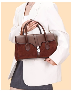Close-up of vintage suede and leather patchwork handbag with silver clasp and base studs