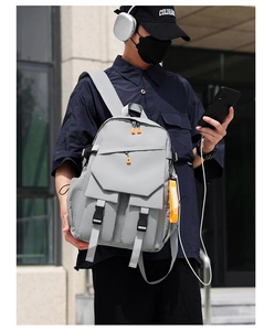 Waterproof light grey urban backpack with orange zipper accents shown on a model