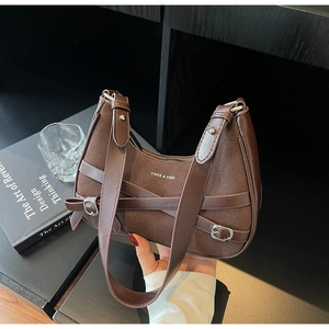 Détail du sac croissant marron foncé avec texture mate et boucles contrastées