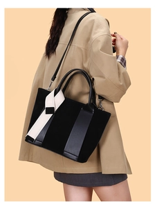 Detail of black leather tote bag with a trendy black and white contrast wide strap