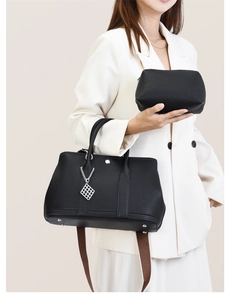 Detail of black pebbled leather tote bag with silver hardware and detachable small pouch