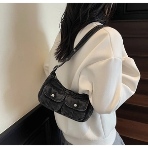 Detail of vintage grey denim shoulder bag featuring double pockets and adjustable strap