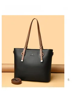 Close-up of black lychee grain leather tote bag featuring a kangaroo logo and brown straps