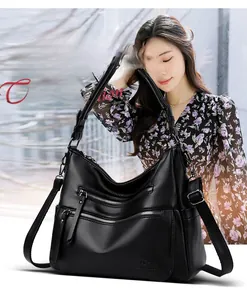 Detail of black lychee grain leather handbag with multi-layer zippers and kangaroo logo