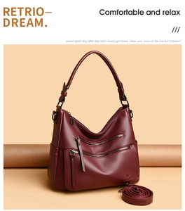 Detail of burgundy hobo bag with three front metal zippers and litchi texture leather