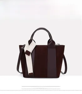 Detail view of brown vintage tote bag with mixed textures and cream canvas strap