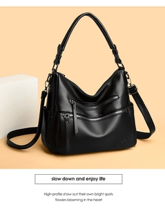 Detail of black lychee grain leather tote bag with functional dual metal zippers