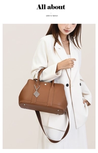 Close-up of brown litchi pattern leather tote with silver pendant and protective studs