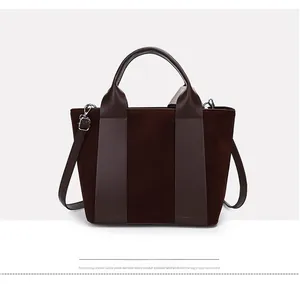 Detail of vintage brown suede bucket bag with contrast leather handles and strap