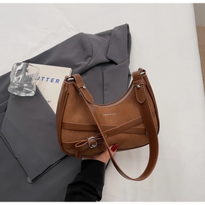 Détail du sac bandoulière marron en daim avec boucle nœud et lanières en cuir