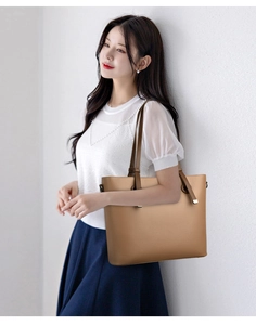 Detail of khaki tote bag showing textured synthetic leather and dark brown shoulder straps