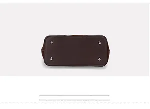 Detail view of the brown leather bucket bag bottom with protective silver metal rivets