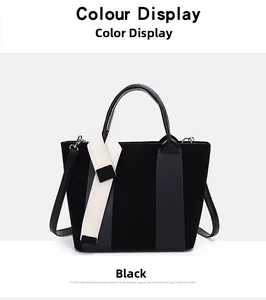 Detail of black tote bag featuring mixed textures and a wide striped canvas shoulder strap