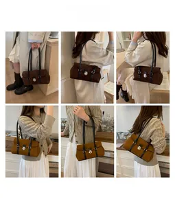 Detail showing vintage suede baguette bag with metal buckle in coffee and caramel tones