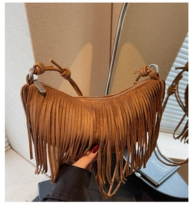 Detail of brown suede shoulder bag featuring long tassels and knotted strap design
