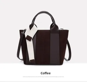 Detail of coffee brown bucket bag with mixed textures and decorative white strap