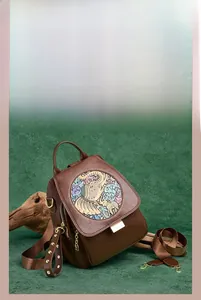 Detail of dark brown leather backpack with colorful elephant relief and vintage hardware
