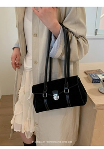 Detail of black suede underarm bag featuring white contrast stitching and silver turn-lock