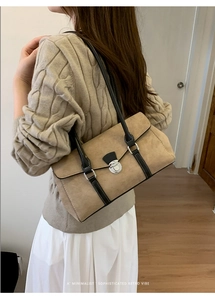 Close-up of minimalist retro shoulder bag with silver twist lock and suede texture