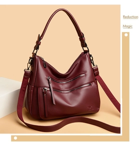 Detail view of burgundy pebble leather shoulder bag with multiple zippers and kangaroo logo