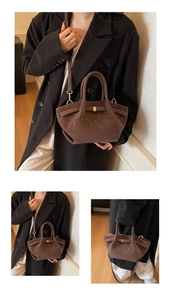 Detail of dark brown matte leather wing bag featuring retro pleats and metal buckle