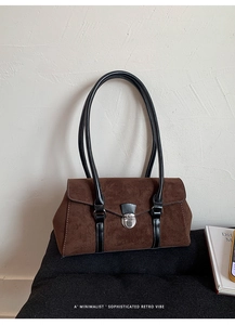 Detailed close-up of dark brown suede texture and silver metal twist lock on retro bag