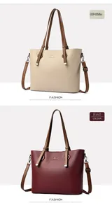 Close-up of cream and red litchi grain leather tote bags with brown handles and kangaroo logo