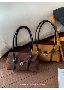 Detail of suede baguette bags in dark brown and caramel with sleek metal buckles