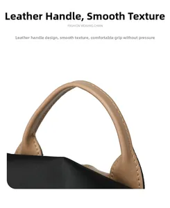 Detail of tan leather handle and stitching on black large capacity travel backpack