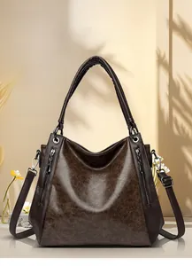 Macro view of vintage brown oil wax leather texture with metal zipper detail on tote bag