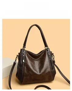 Detail of dark brown vintage leather tote with metal zippers and wide handle