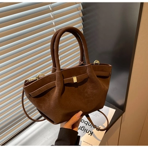 Macro view of matte brown retro wing bag showing pleat details and gold square metal buckle