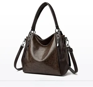 Macro side view of brown vintage tote bag showing faux leather texture and metallic hardware