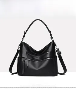 Front detail of black grainy leather handbag featuring decorative zippers and kangaroo logo