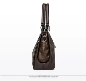 Side view of large vintage dark brown tote bag with oily leather texture and metal D-rings