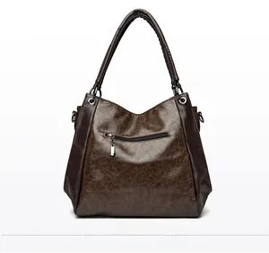 Detail view of the back of a large vintage brown tote bag with a functional zipper pocket