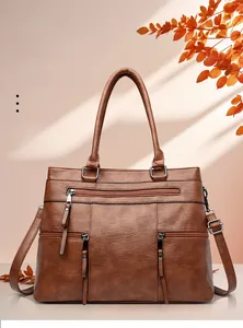 Close-up of vintage brown tote bag showing pebbled leather texture and zipper pockets